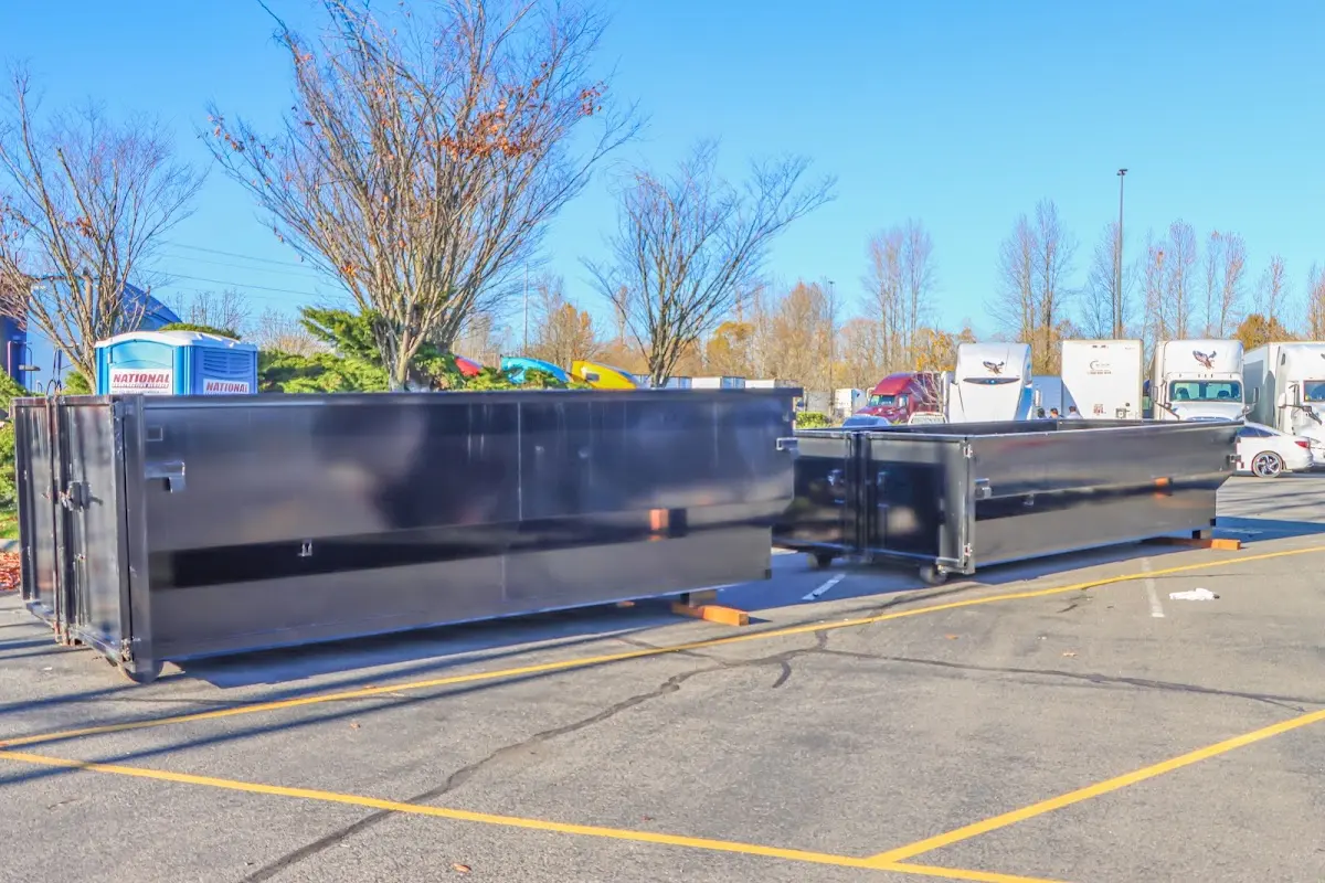 Professional dumpster rental service with roll-off container on residential driveway in Wells Branch